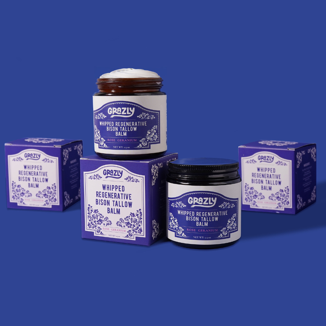 Purple boxes and jars labeled 'Whipped Regenerative Bison Tallow Balm' on a blue background.
