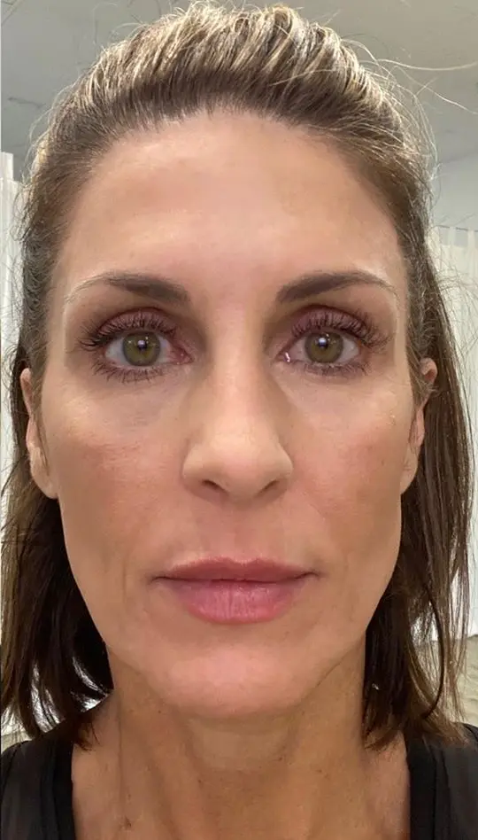 Close-up of a woman's face with green eyes and brown hair.