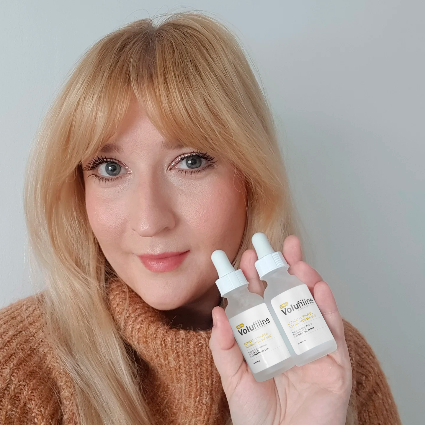 Person holding two bottles labeled 'Volufiline' against a plain background.