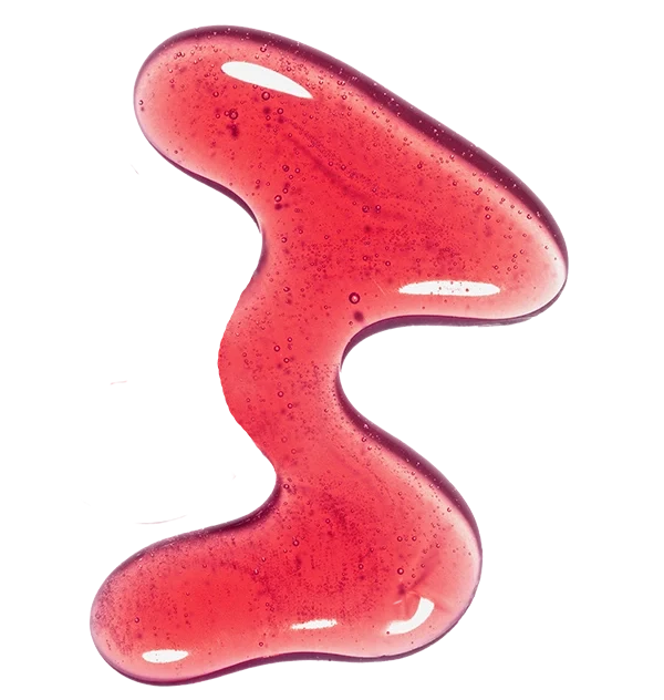 A wavy smear of translucent red gel with tiny bubbles on a white background.