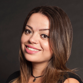 Smiling woman with long brown hair against a dark background.