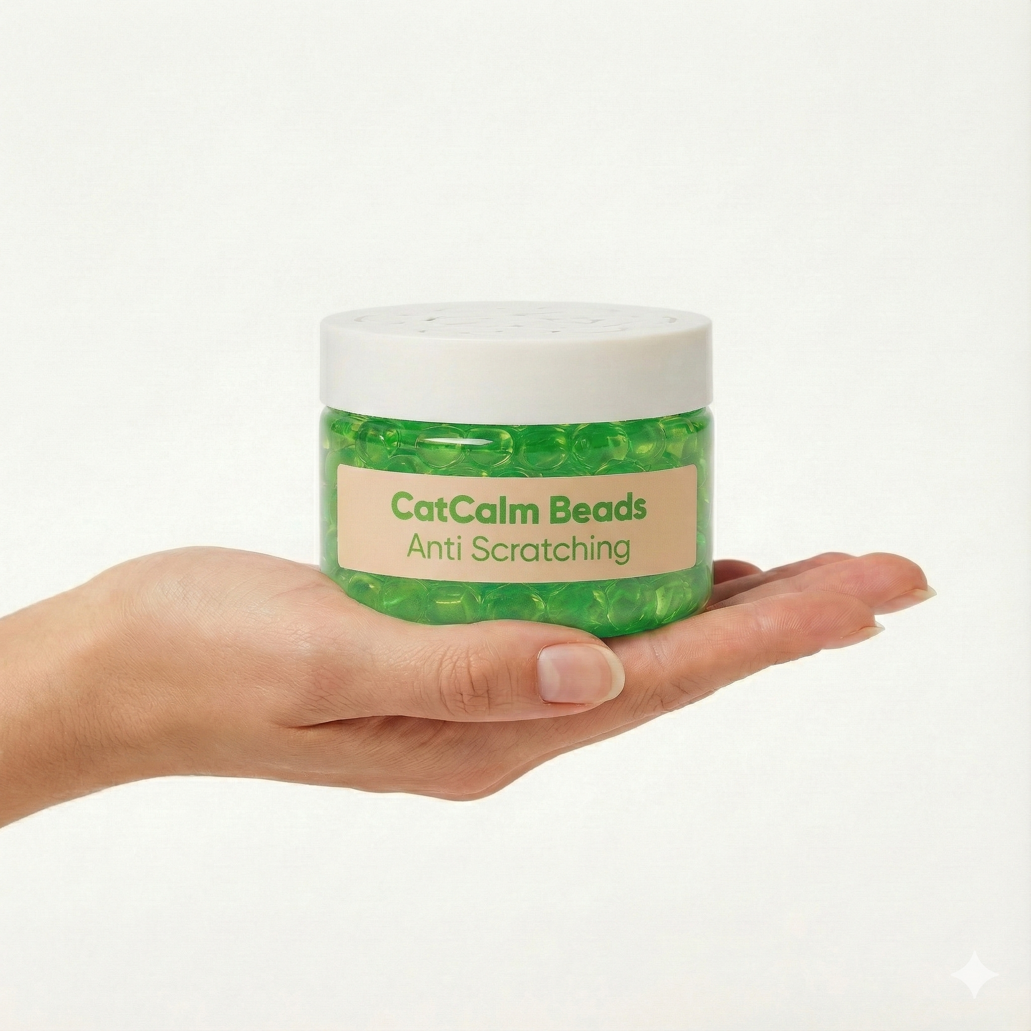 A hand holds a jar of green CatCalm Beads for anti-scratching against a white background.