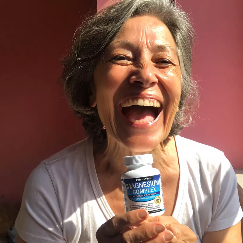 Smiling person holding a bottle of magnesium complex.