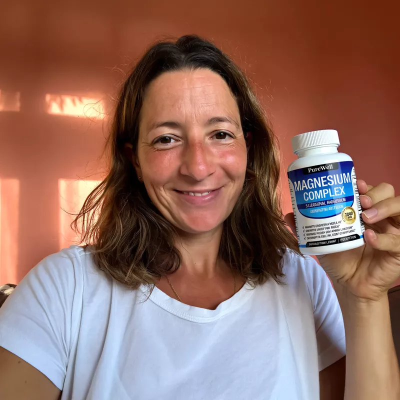 Person holding a bottle of magnesium complex against a reddish background.