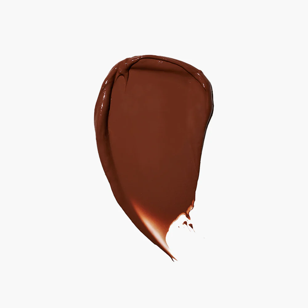 A smear of dark brown cream on a white background.