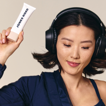 Person wearing headphones holding a tube labeled 'Jones Road.'