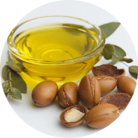 Un cuenco de aceite amarillo rodeado de nueces y hojas.