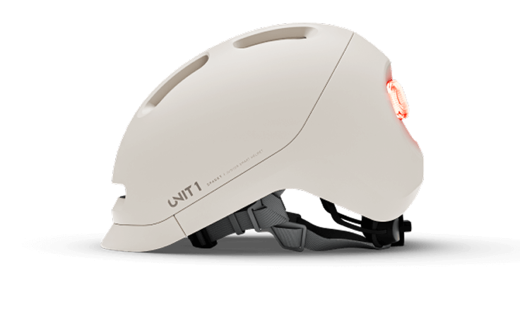 White bicycle helmet with rear light and adjustable strap.