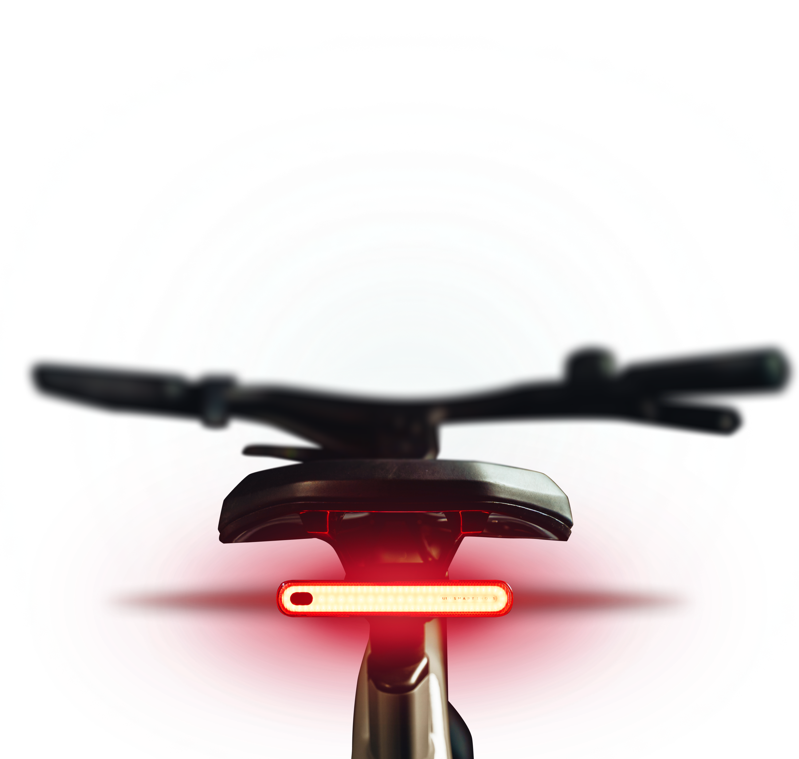Close-up of a bicycle handlebar and rear light with colorful light trails.