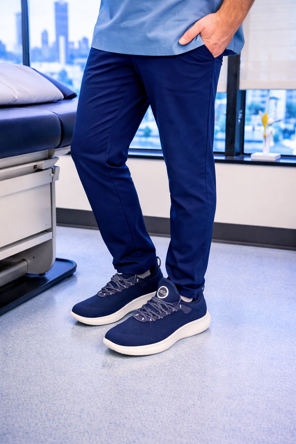 Two pairs of blue and black sneakers on a blue floor.