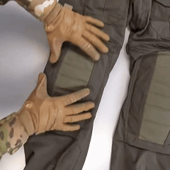 Gloved hands adjusting knee pads on tactical pants.