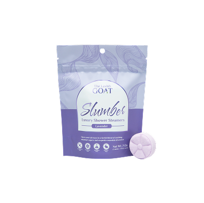 Lavender shower steamer packaging with a round lavender tablet beside it.
