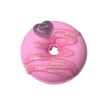Pink donut-shaped bath bomb with glitter and a heart decoration.