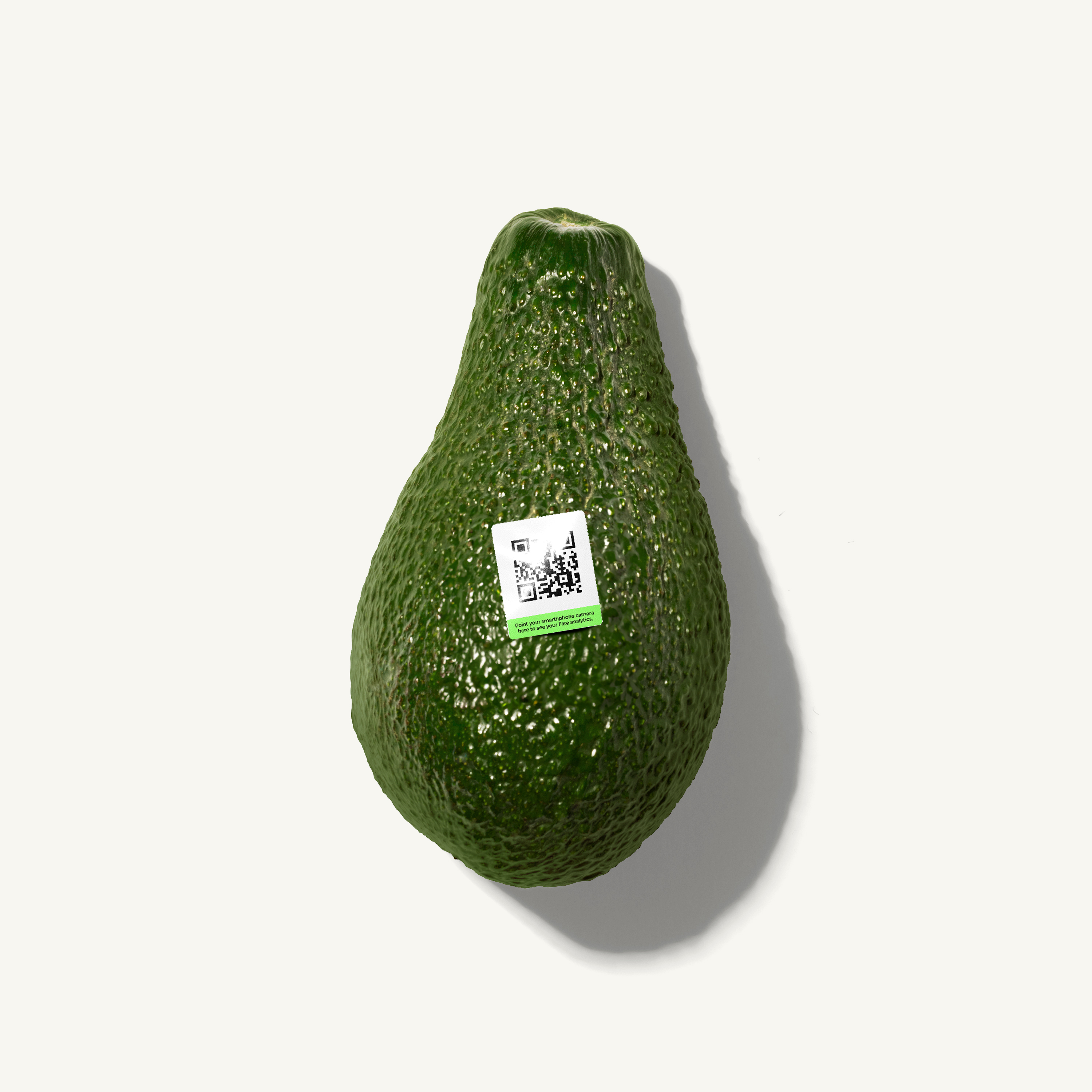 A single avocado with a QR code sticker on a light background.
