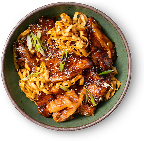 Bowl of noodles with meat, green onions, and sesame seeds.