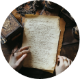 Hands writing on aged paper surrounded by vintage items.