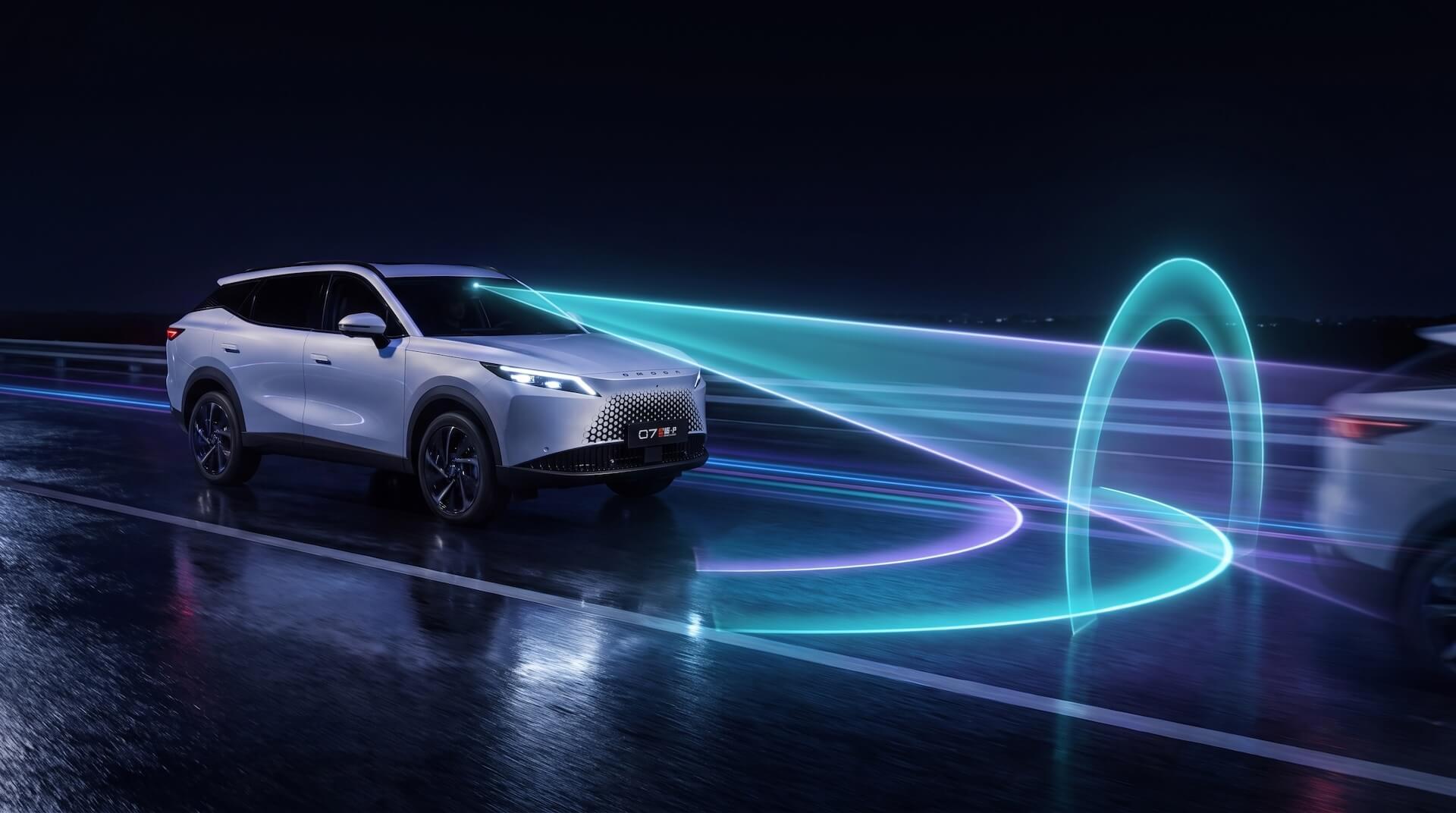 A white SUV on a wet road at night, with glowing light trails demonstrating its driver-assist technology.