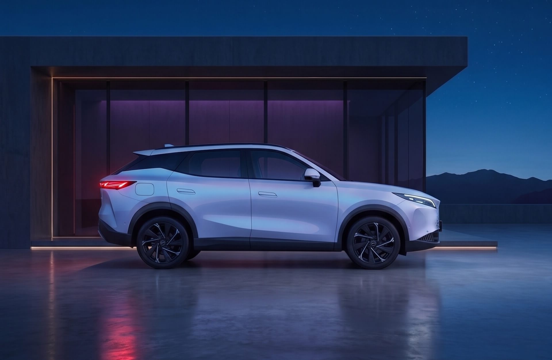 A light-colored SUV parked outside a modern, illuminated building at dusk with mountains in the background.