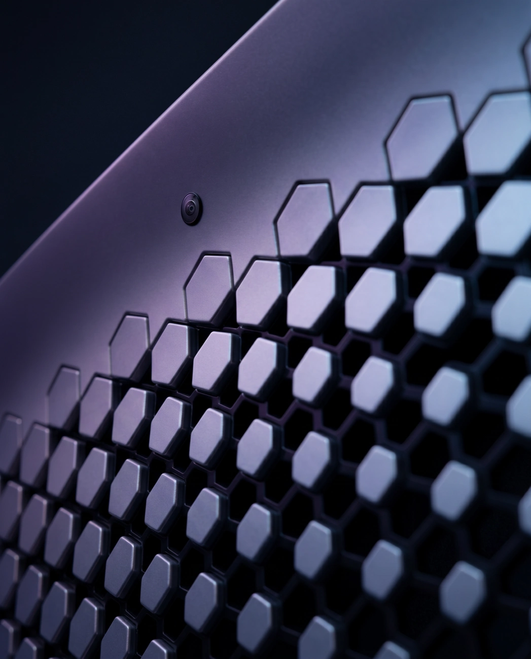 A close-up, angled view of a dark surface with a hexagonal grille and a small camera lens.