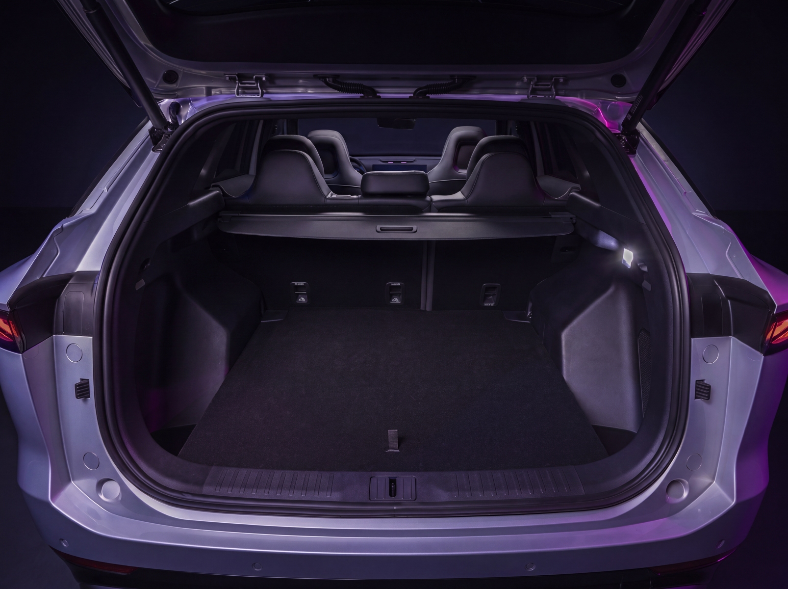 A rear view of a silver car with its hatchback open, showing the spacious, empty trunk.