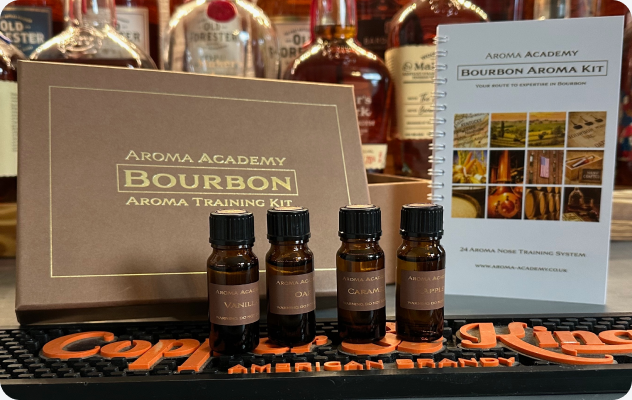 Bourbon aroma training kit with bottles and a guidebook displayed on a bar mat.