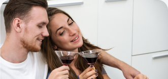 A couple enjoying glasses of wine at home.