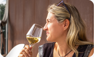 Woman enjoying a glass of white wine outdoors.