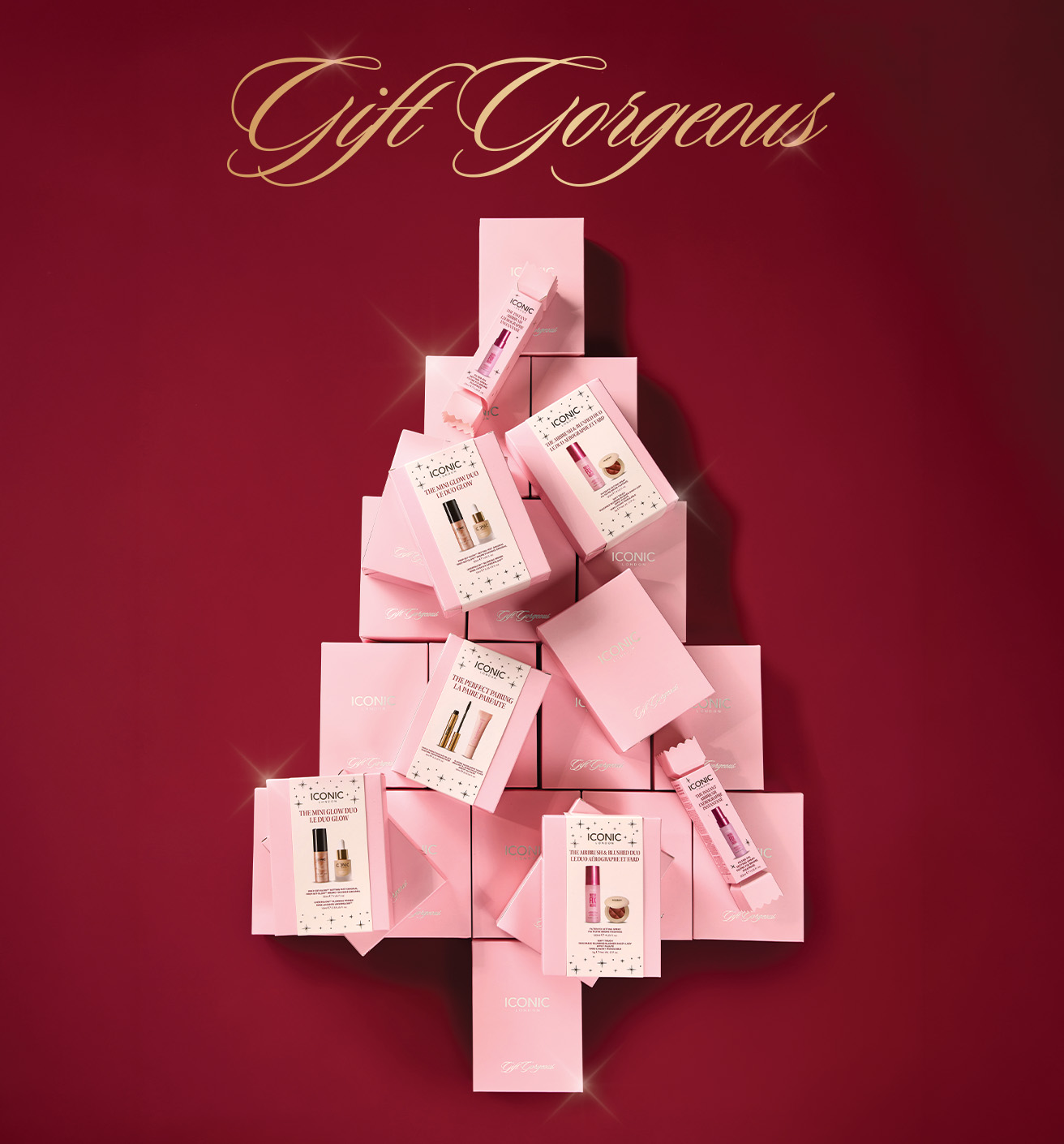 ICONIC cosmetic gift sets arranged in the shape of a Christmas tree on a red background.