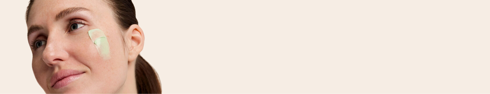 Woman with long hair making a playful face against a plain background.