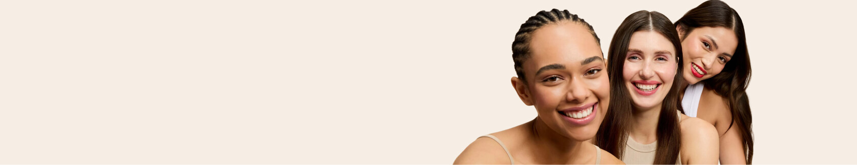 Three smiling women against a plain background.