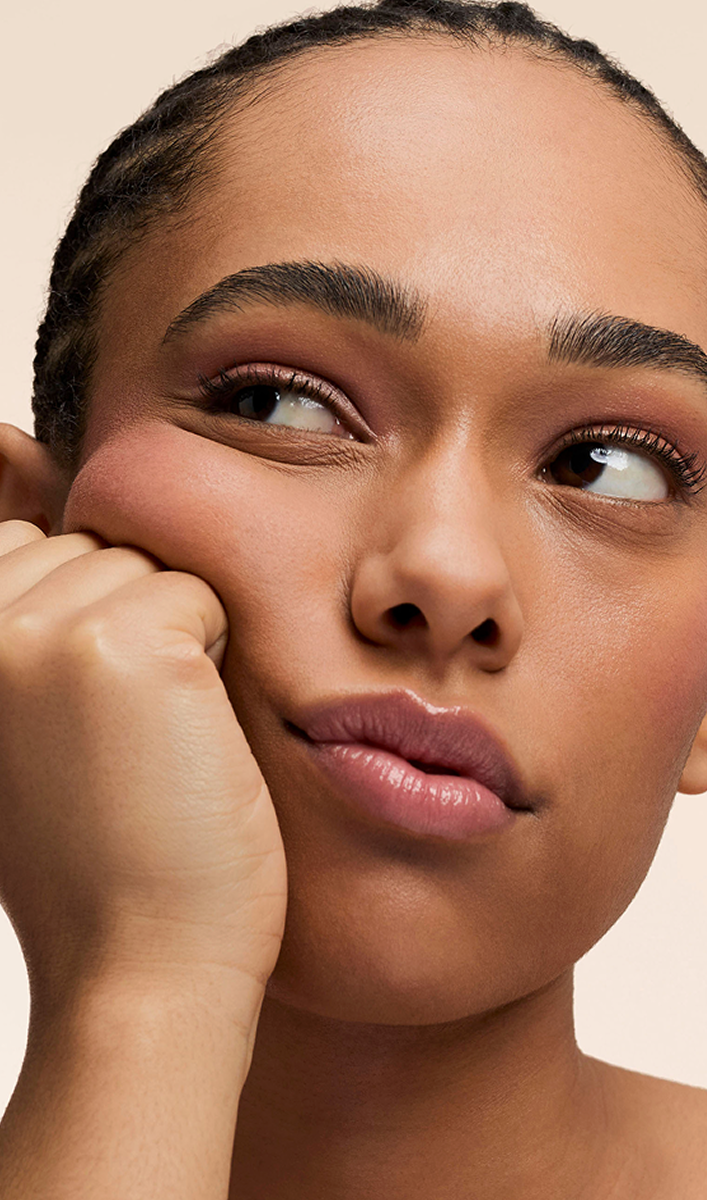Close-up of a person resting their chin on their hand, looking sideways.
