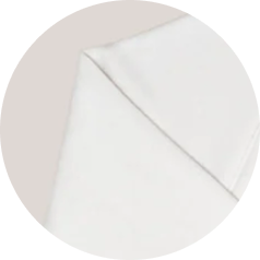 A close-up of the folded corner of a white piece of fabric, shown within a circular frame.
