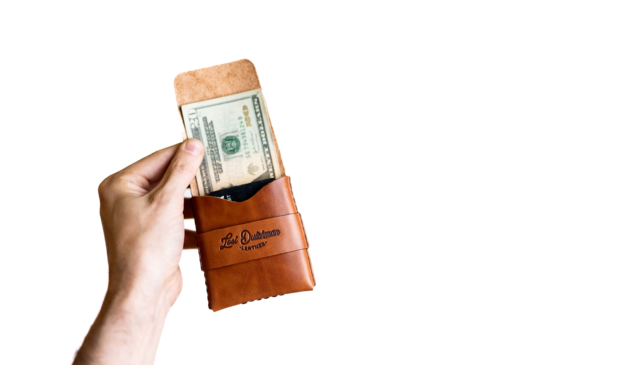 A hand holding a brown leather wallet with a twenty-dollar bill sticking out.