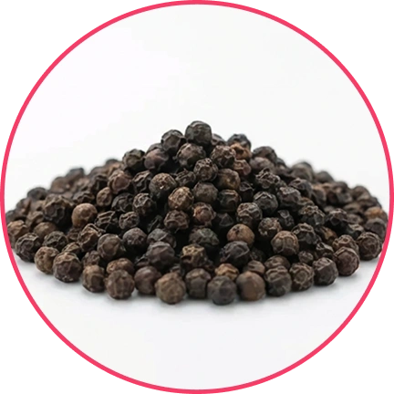A pile of black peppercorns on a white surface.