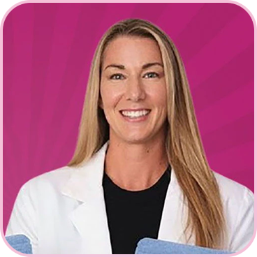 A smiling woman with long blonde hair, wearing a white lab coat against a pink background.