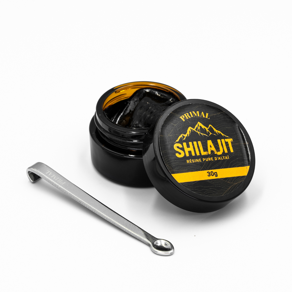 Black jar of Shilajit resin with a small metal spoon.