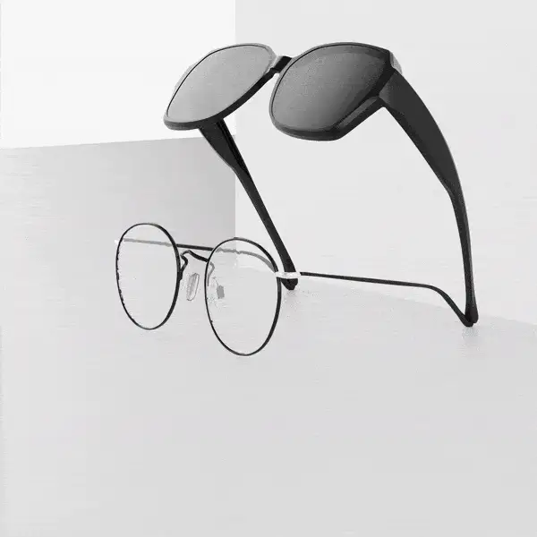 An animation showing a sunglasses attachment clipping onto a pair of round eyeglasses.