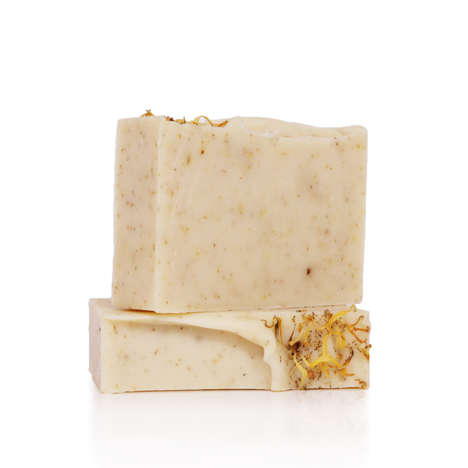 Two natural soap bars stacked, with visible grains and herbs.