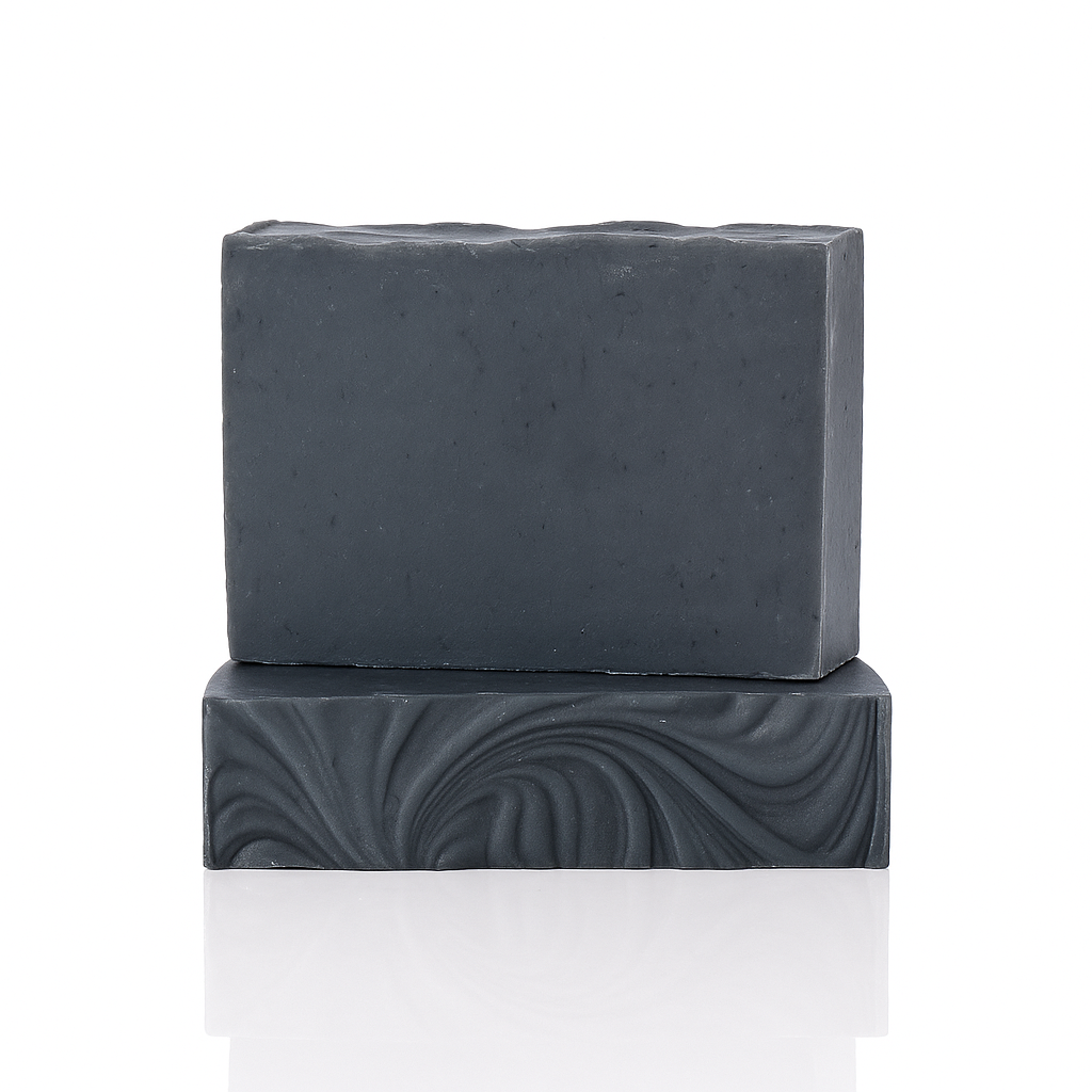 Two stacked blocks of charcoal soap, one textured.