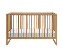 A light wood baby crib with a white mattress against a white background.