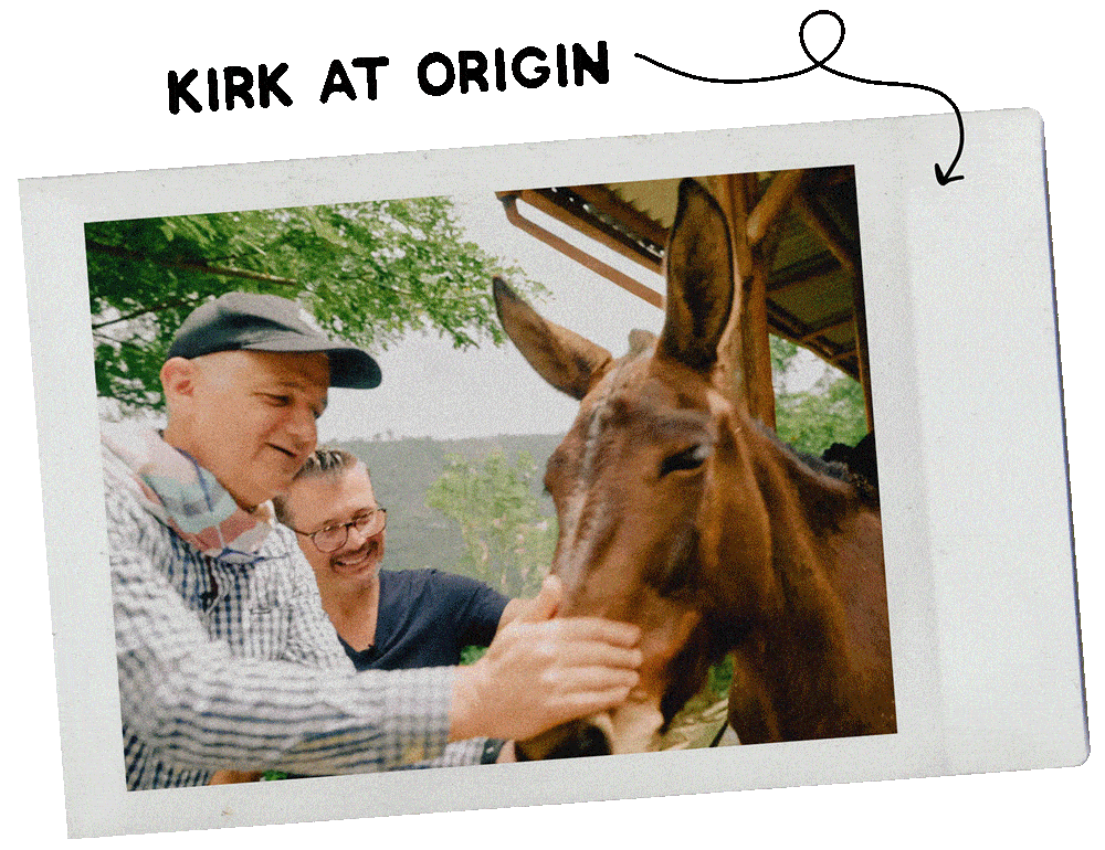 Two people petting a brown horse outdoors.