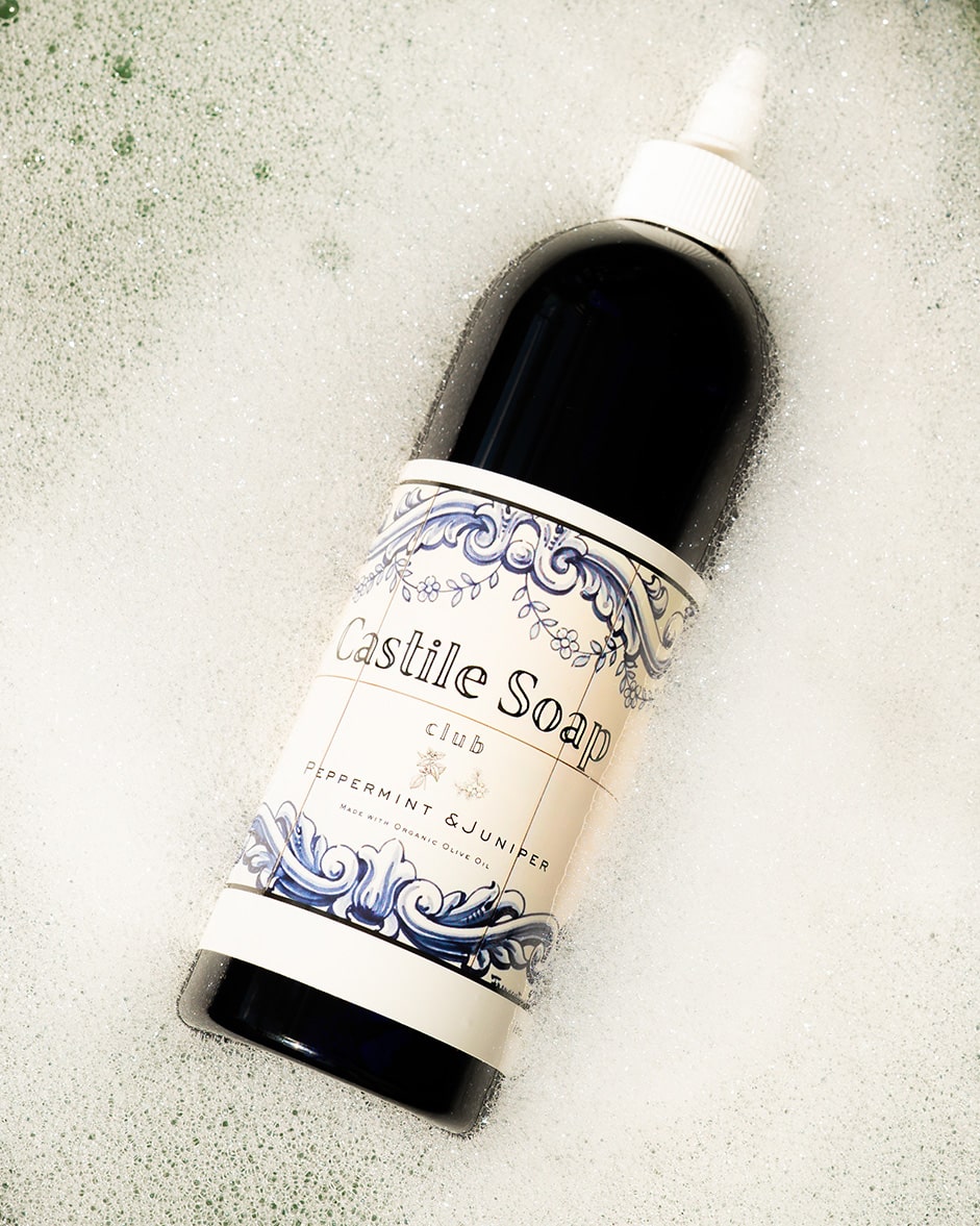 Bottle of Castile soap on a bed of bubbles.