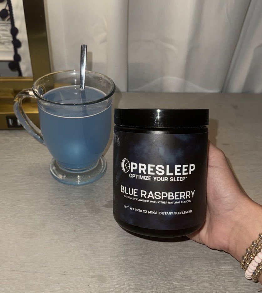 Container of sleep supplement and a glass of blue liquid.