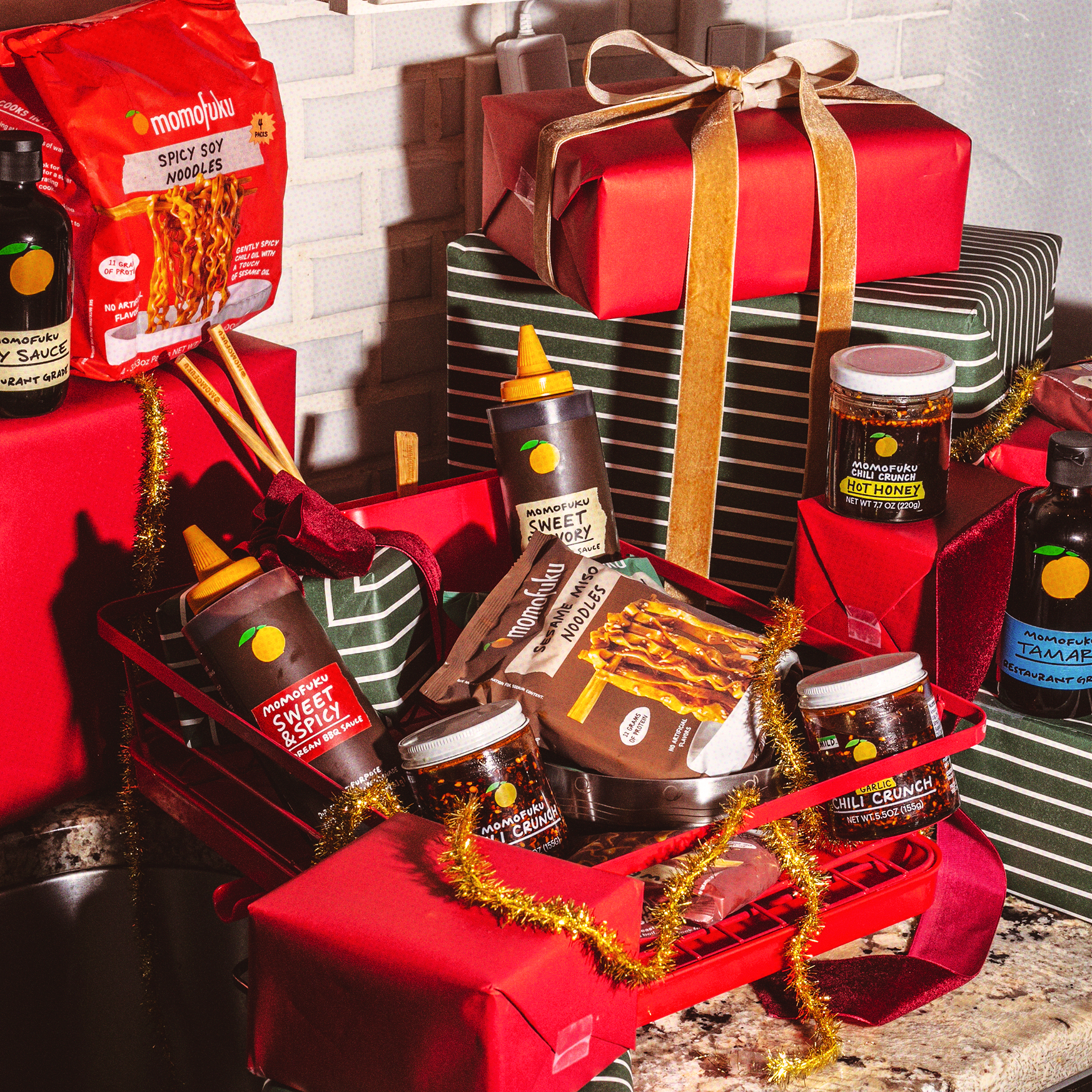 Assorted food products and gifts in festive red and green wrapping.