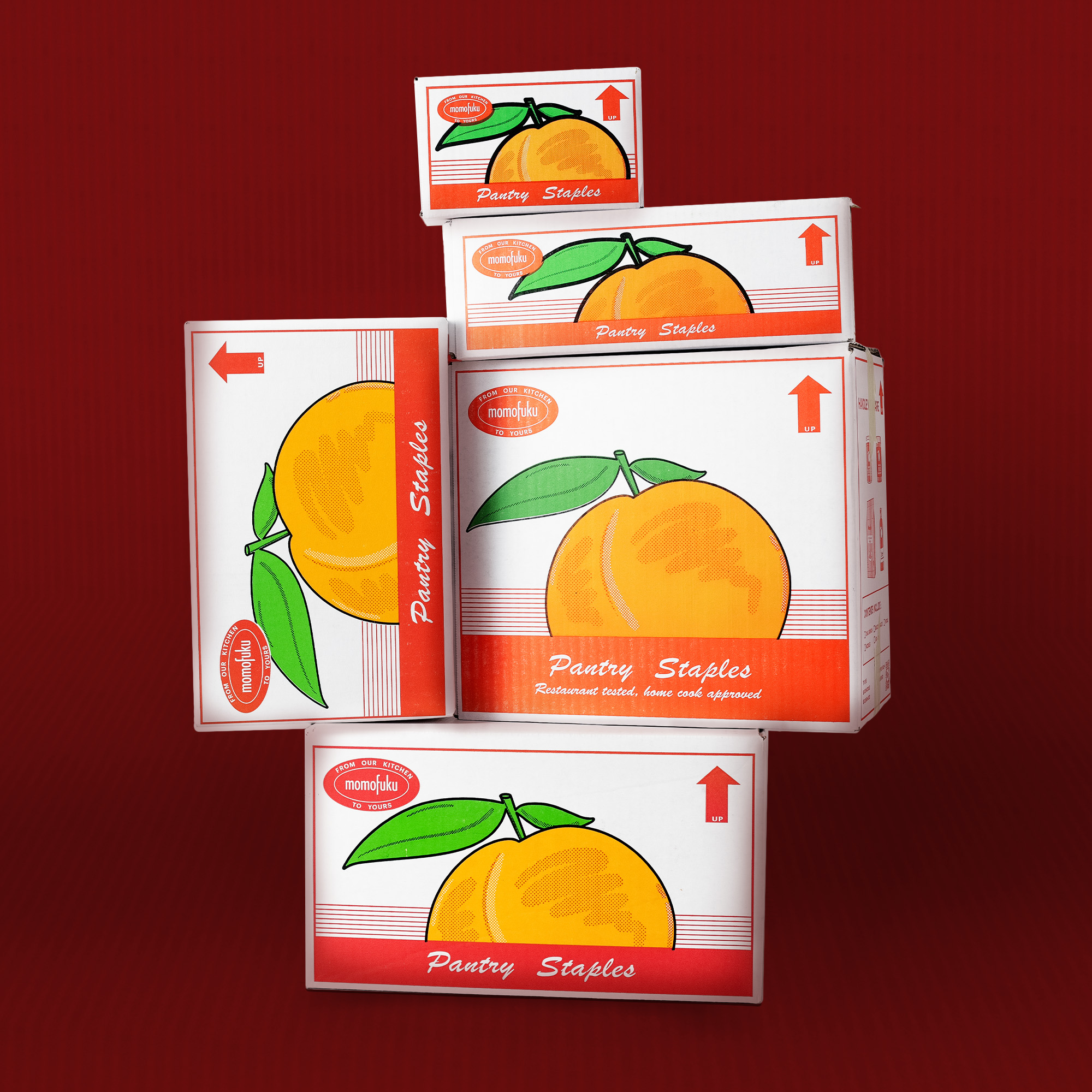 Stacked boxes with orange fruit illustration on a red background.