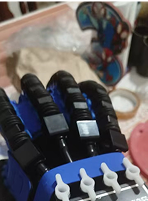 Close-up of a robotic hand with cables visible in the background.