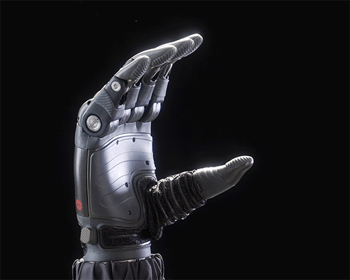 A detailed robotic hand against a black background, fingers partially curled.