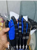 A hand holding a blue and black robotic glove with articulated fingers.