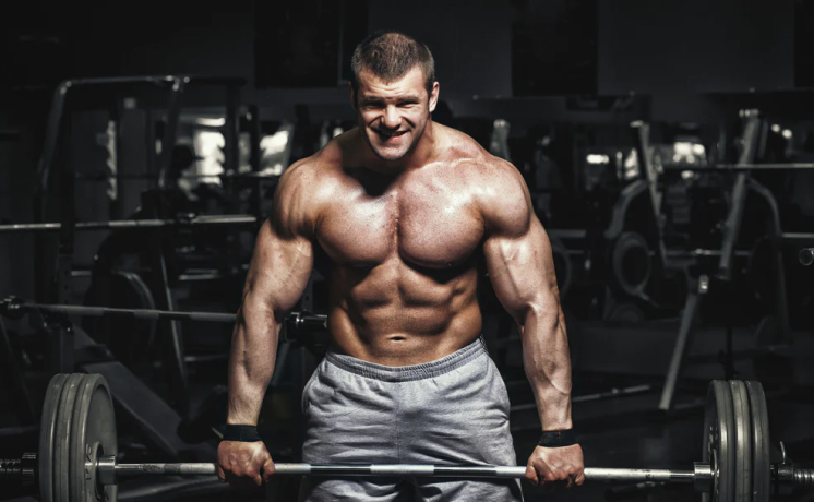 Bodybuilder lifting a barbell in a gym.