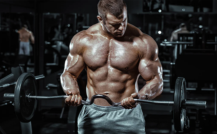 Muscular man lifting a barbell in a gym.